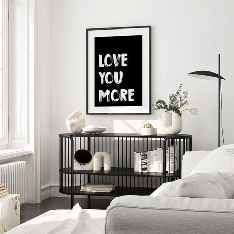 Love you more typography wall art with bold white brush lettering on a black background