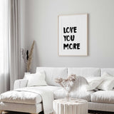 Love you more typography wall art with black brush lettering on a white background