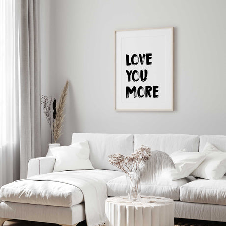 Love you more typography wall art with black brush lettering on a white background