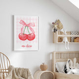 Ma chérie cherry print featuring a pink bow joining two red cherries above French text on a pale pink gingham background.