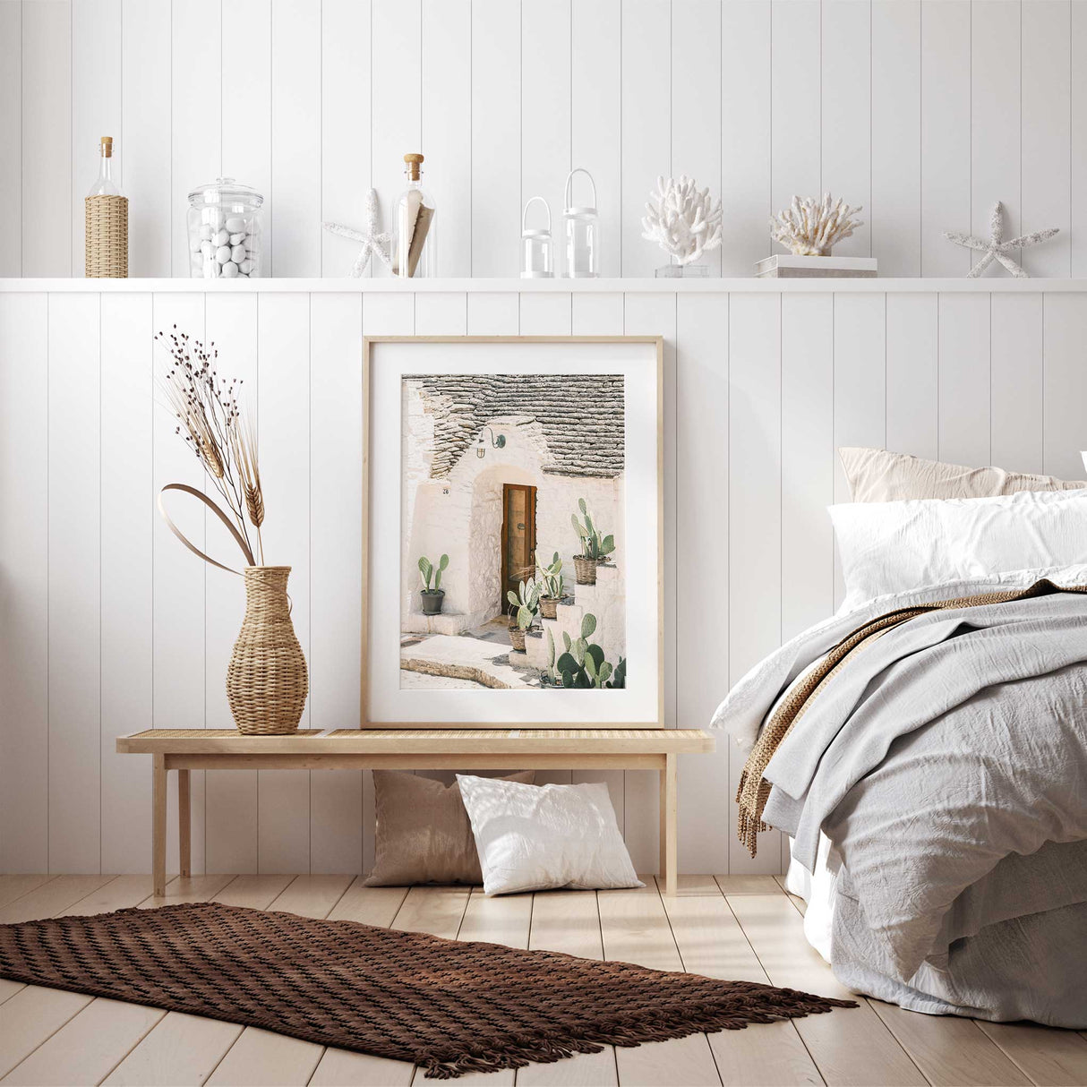 Mediterranean wall art featuring a brown door white stone house and cactus

