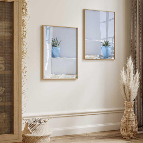 Mediterranean wall art set of two featuring blue plant pots against softly weathered white and pale blue walls