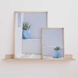 Set of two Mediterranean wall art prints featuring blue plant pots against softly weathered white and pale whitewashed walls