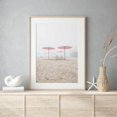 Neutral-toned beach photograph with soft sand and Adirondack chairs