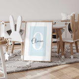 A simple print showcasing a pale muted color with a personalised letter in the background with a handwritten name layered in black.
