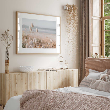 Neutral beach grass wall art with soft cream reeds and pale blue ocean tones in a coastal landscape
