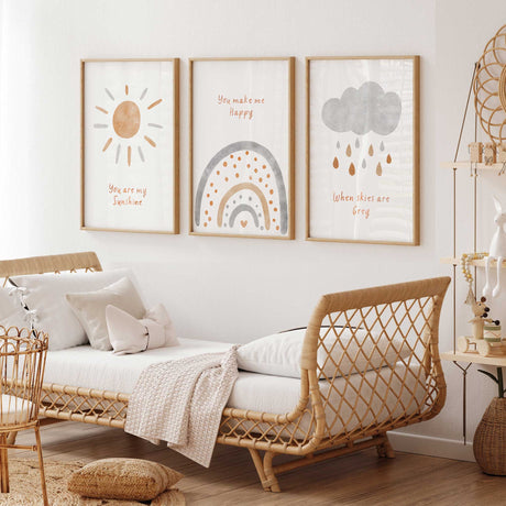 Neutral boho nursery wall art set featuring sun, rainbow and cloud prints in beige and grey tones for baby room decor