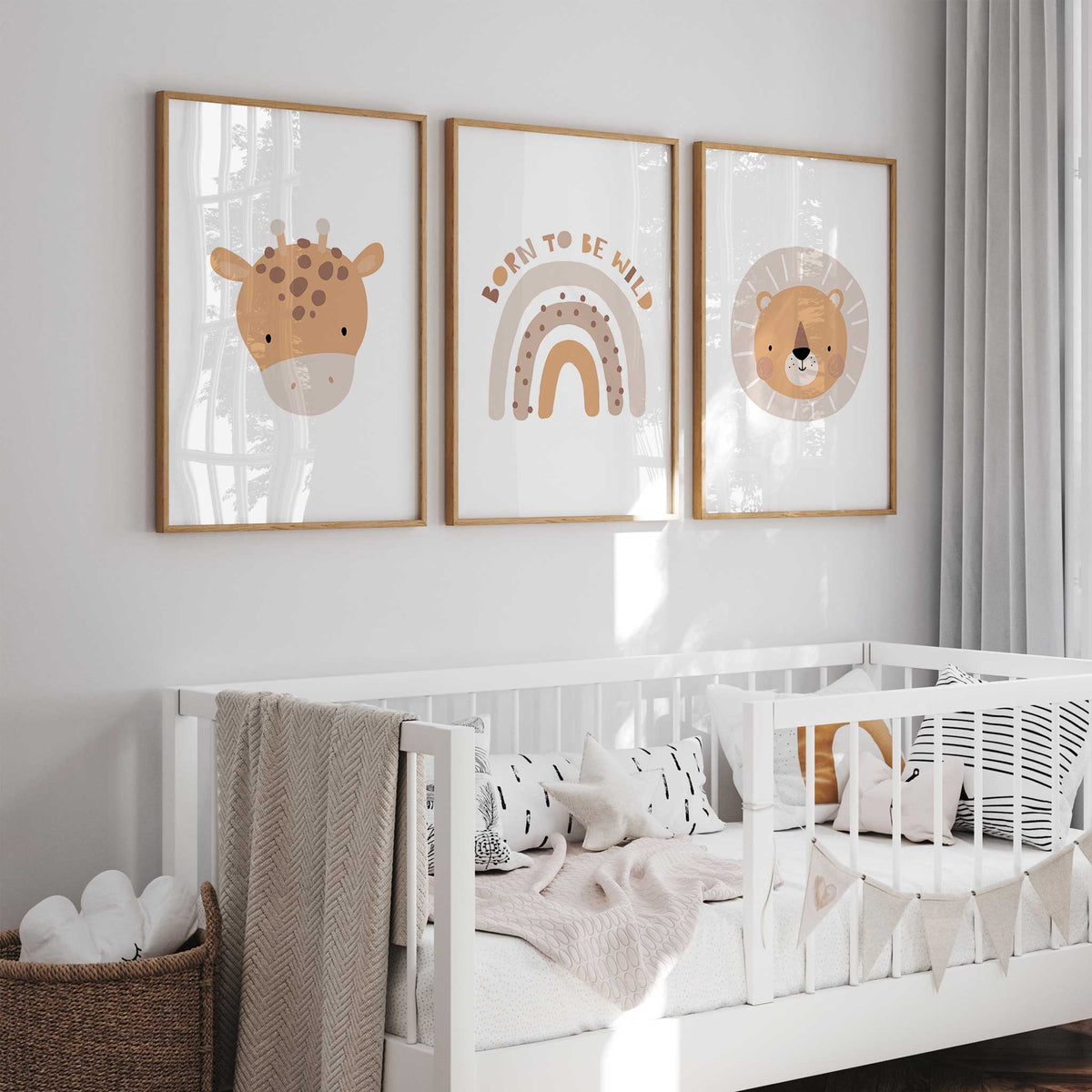 Three coordinating nursery prints showing a giraffe face, a lion face and a neutral rainbow with Born to Be Wild text.