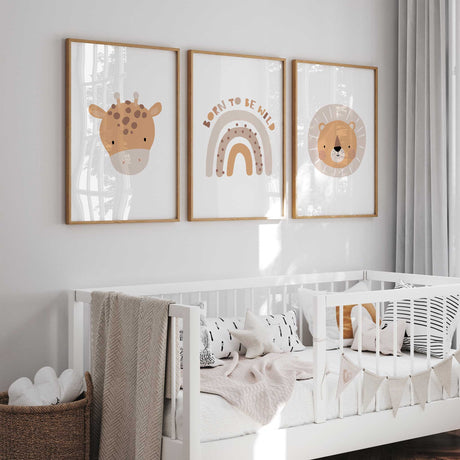Three coordinating nursery prints showing a giraffe face, a lion face and a neutral rainbow with Born to Be Wild text.