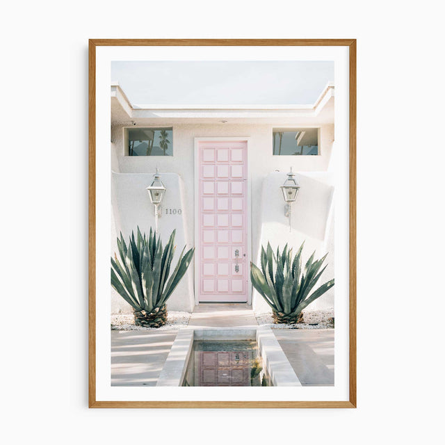 Palm Springs pink door wall art print with white border, mid-century modern home decor photography.
