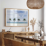 Palm tree beach photography print with soft blue water and white sand for coastal bedroom or living room decor.