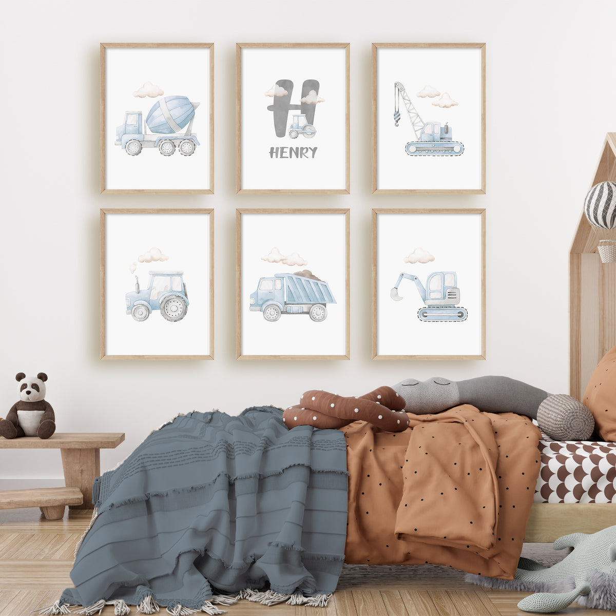 Six blue watercolour construction prints with clouds, five vehicle designs and a grey inital above the name.