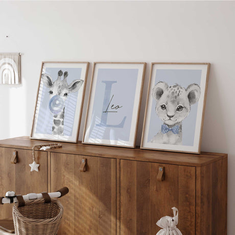 Personalised safari nursery wall art set with giraffe bubble print, custom initial name art and lion cub portrait in soft blue tones