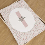 Personalised nursery print with a blush pink initial and name in green script, surrounded by pink roses and green leaves.