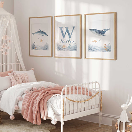Set of three personalised ocean prints featuring a watercolour dolphin, whale and initial name design with shells and starfish.