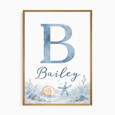 Personalised ocean name print with a blue watercolour initial and name lettering above a shell, starfish and rocky seabed.