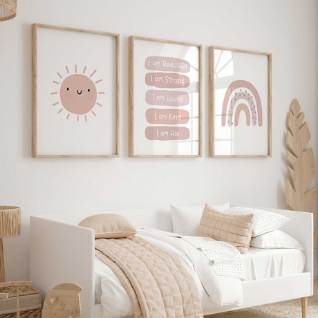 Set of three pink prints showing a smiling sun, personalised affirmations and rainbow