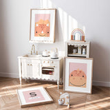 Three personalised pink dinosaur prints displayed together in a girls bedroom, including a custom initial and name design.