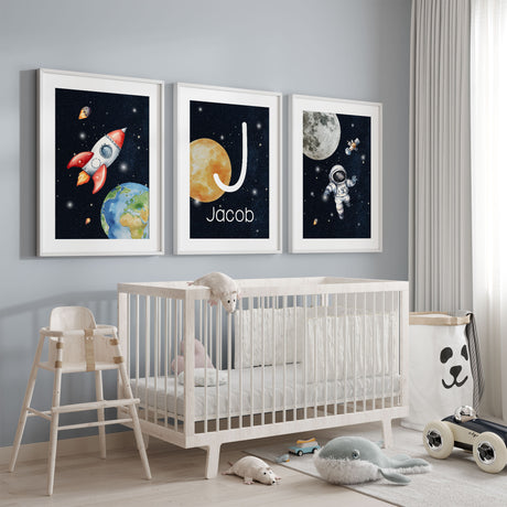 Personalised space nursery wall art set with rocket, astronaut and custom initial name print in deep navy tones for boys bedroom decor