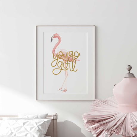 artwork with a pink flamingo and 'You Go Girl' text on a white wall.