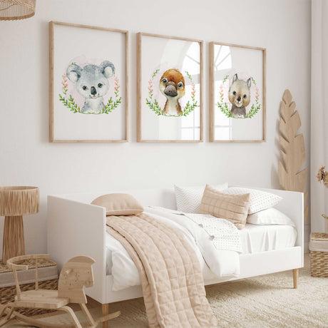 Koala, platypus and wombat watercolour portraits with green leafy wreaths, pink flowers and pale pink backgrounds.