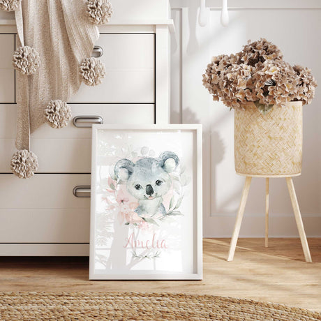Koala name print featuring name in pink script, with a grey watercolour koala surrounded by flowers and foliage.