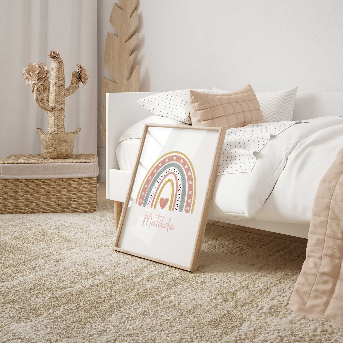 Pink rainbow nursery print personalised with a child's name beneath colourful arches decorated with small heart details