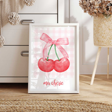 Girls wall art print showing a pair of red cherries with a pink ribbon bow and delicate pink checked background.