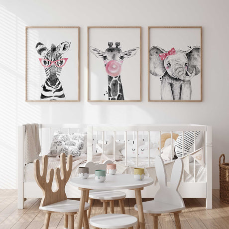Pink safari animal nursery wall art set featuring zebra with glasses, giraffe blowing bubble gum, and elephant with bow