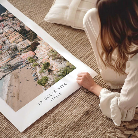 Positano photography print showing pastel hillside buildings and a beach, with La Dolce Vita Italia text below.
