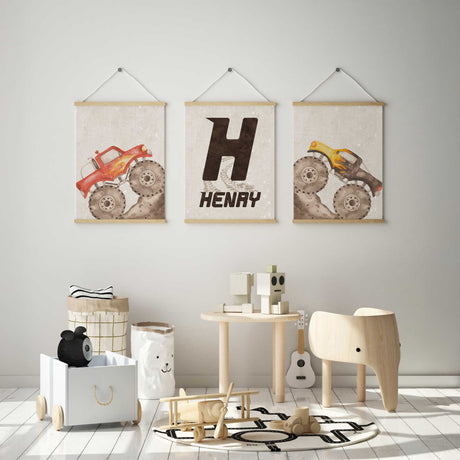 Red and yellow monster truck prints with a personalised Henry initial print, muddy tyres and pale beige backgrounds.