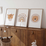 Set of three safari nursery prints featuring a giraffe, lion and Born to Be Wild rainbow in beige, tan and ochre.