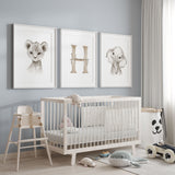 Safari nursery wall art set of three featuring a baby lion cub, baby elephant and personalised initial print in soft neutral tones