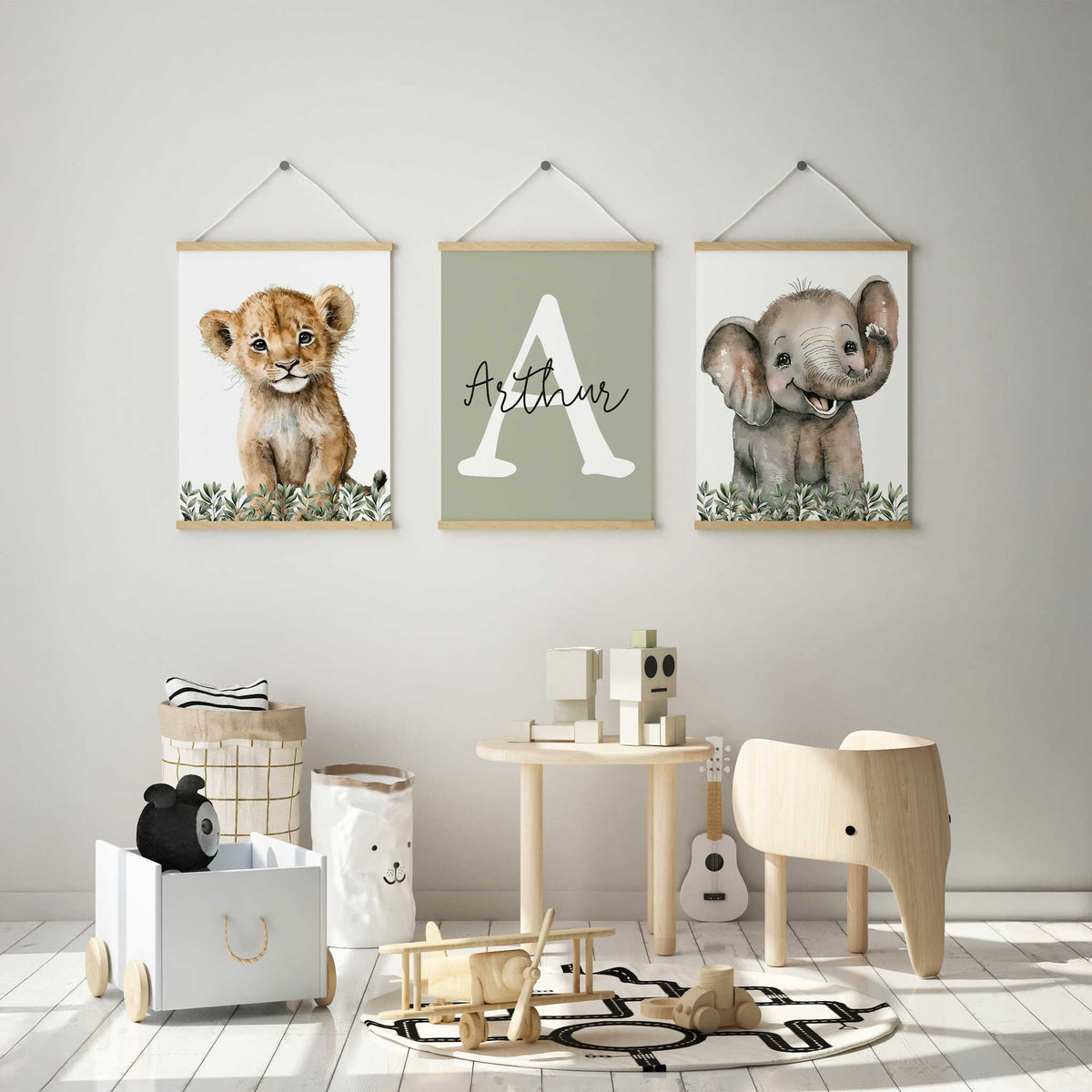 Safari animal trio featuring a lion cub, smiling elephant and white initial with personalised name on a sage green background.