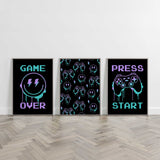 Three unframed gaming themed prints for boys bedroom including 'GAME OVER' text with a smiley face, game controller pattern, and 'PRESS START' text."