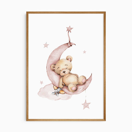 Sleeping tan teddy bear on a dusty pink crescent moon, with a small toy aeroplane, a pink cloud and hanging stars.