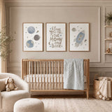 Space nursery wall art set of 3 featuring a rocket, planets and moon quote in soft blue and neutral tones for a baby boy nursery with the quote i love you to the moon and back