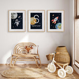 Set of three navy space prints featuring an astronaut, rocket and personalised initial name artwork for a child’s room