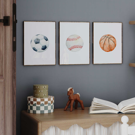 Sports ball print set featuring a blue-grey soccer ball, red-stitched baseball and orange watercolour basketball.