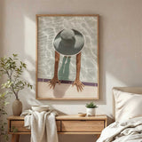 Swimming pool wall art featuring an overhead view of a woman in an oversized sunhat with her hands on the pool edge.