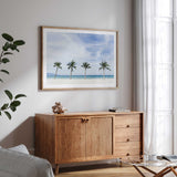 Tropical beach wall art print featuring tall palm trees and clear turquoise water for coastal inspired interiors.