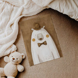 Unframed polar bear print with a striped brown top hat, spotted bow tie and mustard cheeks against a textured brown background.