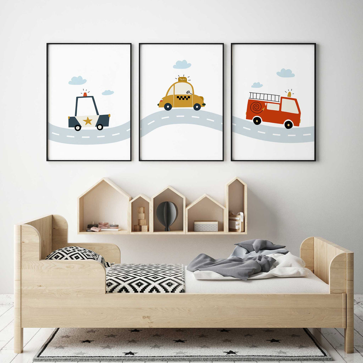 Set of three vehicle wall art prints with a police car, yellow taxi and red fire engine on a pale blue road.
