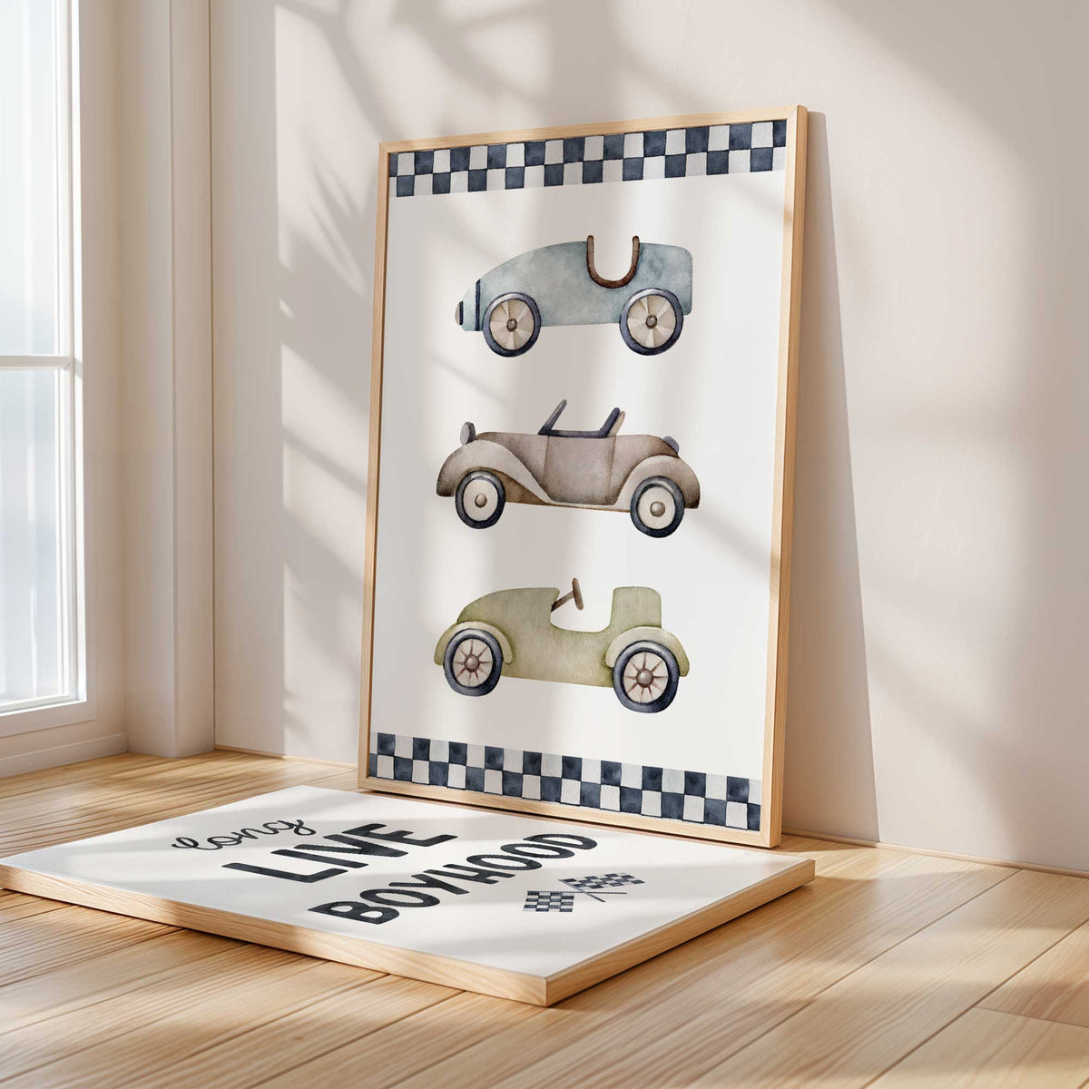 Two racing prints with blue, taupe and olive vintage cars, checkered borders and a black Long Live Boyhood quote on white.
