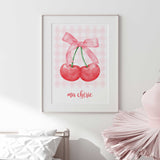 Watercolour-style cherry artwork featuring rich red fruit, a soft pink fabric bow and classic pink checked details.