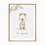 Watercolour wombat artwork with be smart lettering, pink flowers and green leaves above a pale grey background.