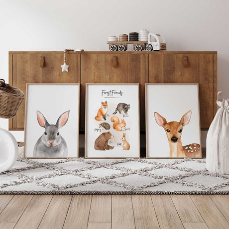 Set of three woodland nursery prints showing a bunny portrait, a group of forest animals and a deer portrait