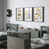 Yellow construction wall art set of three with stacked vehicles, navy lettering and a tower crane reading Build Your Dreams.