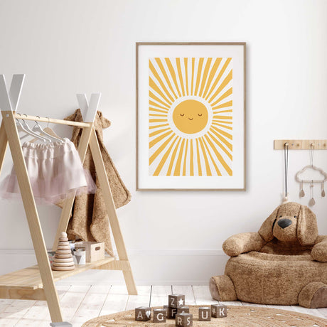 Nursery sun artwork showing a golden yellow smiling face surrounded by long irregular rays on a light background.