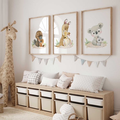 Platypus, kangaroo and koala mother and baby illustrations in brown and grey tones, with green foliage on white.